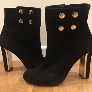 Black Gucci boots with gold detailed heel